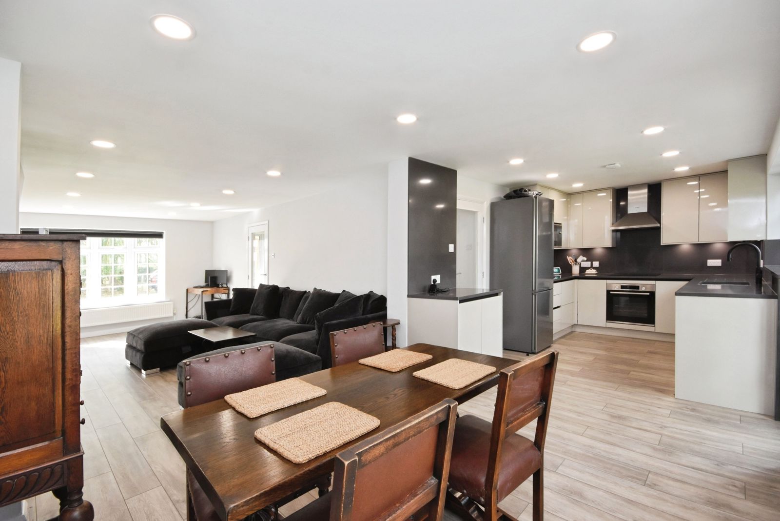 Open-plan living space with dining table, lounge and kitchen beyond